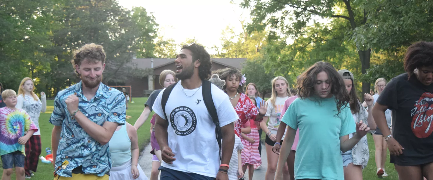 Staff and campers dancing outside