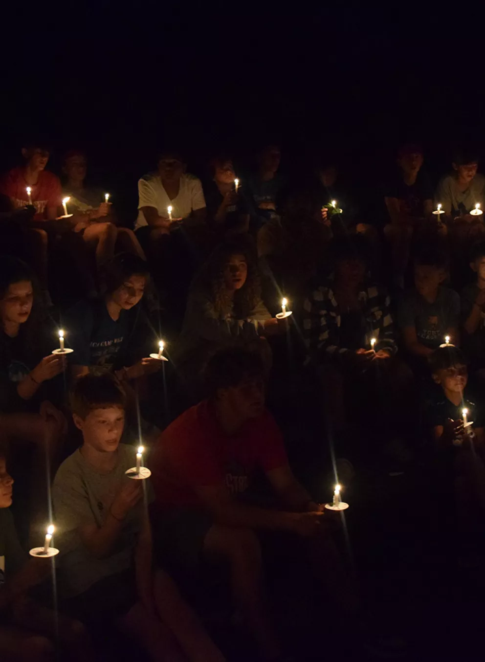 kids holding candles in the dark