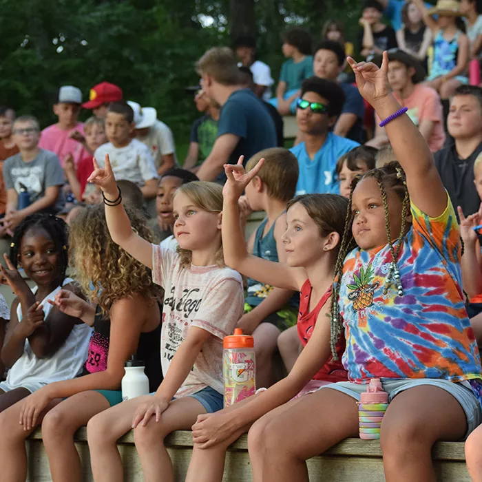 Campers raising their hands