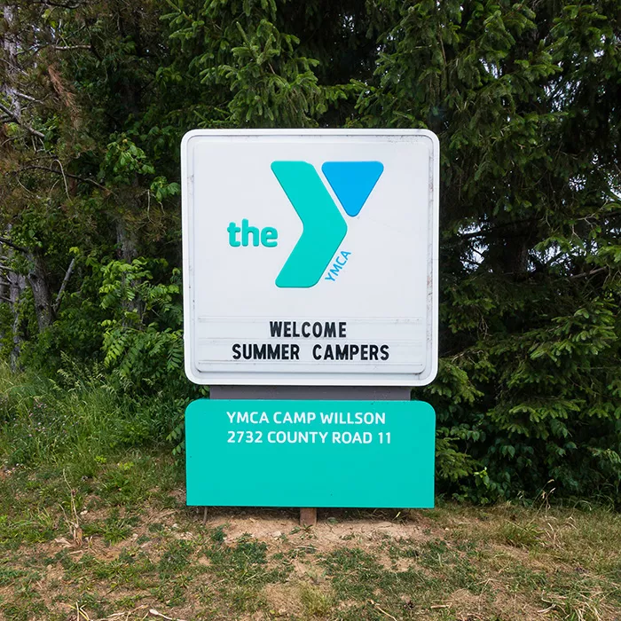 Camp Willson sign that reads Welcome Summer Campers with YMCA logo and camp address