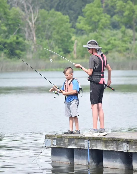 Camper and staff fishing on the lake