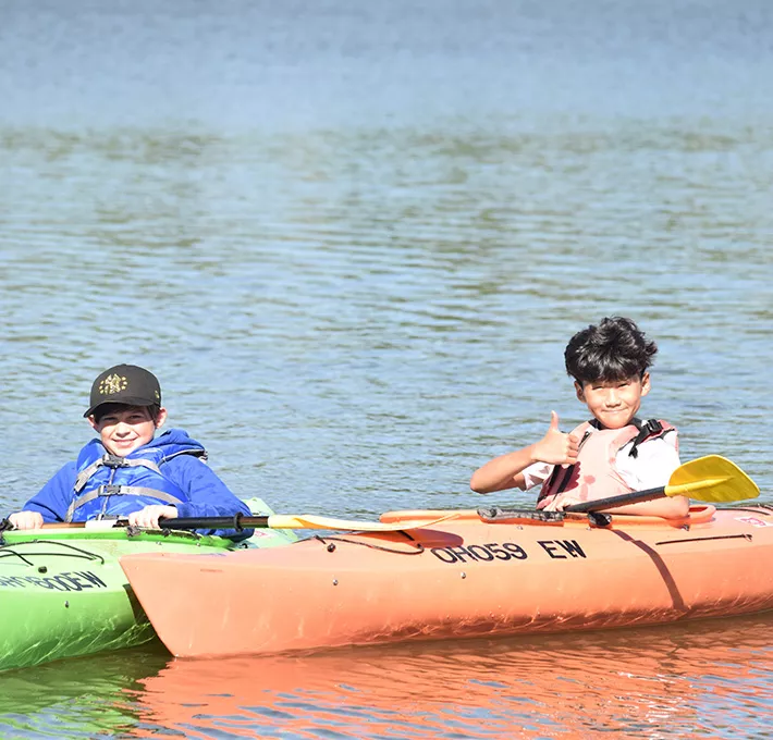 Two campers in kayaks on the water