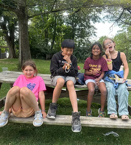 children sitting on a picnic table outdoors