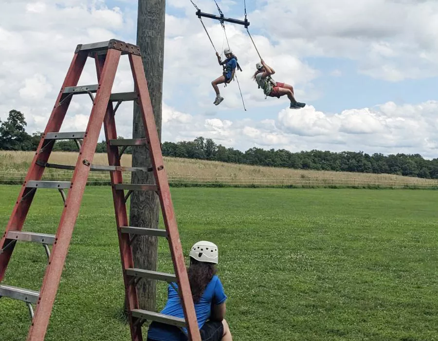 Campers on giant swing with staff looking on