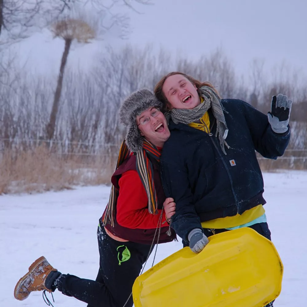 Two campers laughing outside in the snow